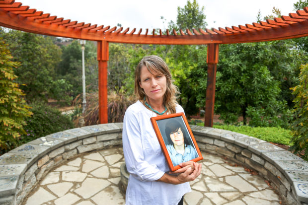 Katharine Prescott, holds a photo of her late son Kyler Prescott, in the memorial garden they created in his memory at thir home in Vista, California September 21, 2016.