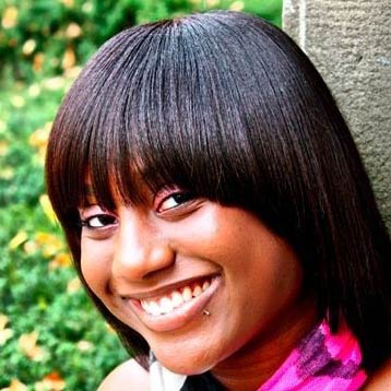 A black woman with beautiful, straight, bob, hair cut. she has a big friendly smile.
