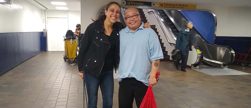 TLC Legal Director Lynly Egyes stands with her arm around Chin Tsui in a hallway at an airport.